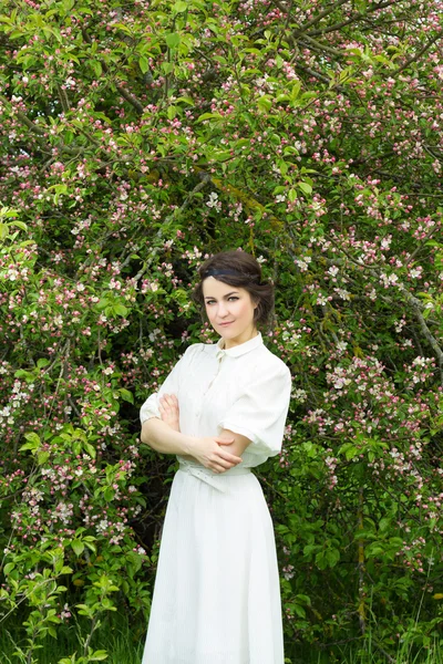 Belle femme debout près de fleurs de pommier — Photo