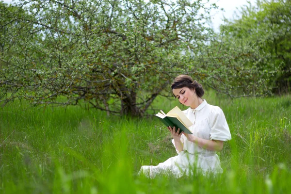 Красивая женщина, читая книгу на летнем лугу — стоковое фото