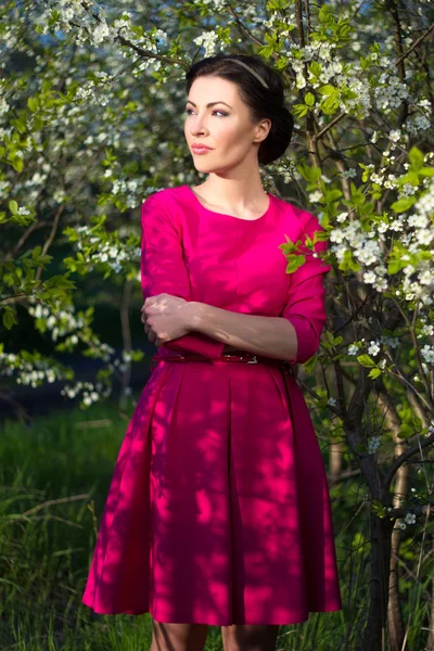 Retrato de uma jovem mulher bonita posando no jardim florescendo — Fotografia de Stock
