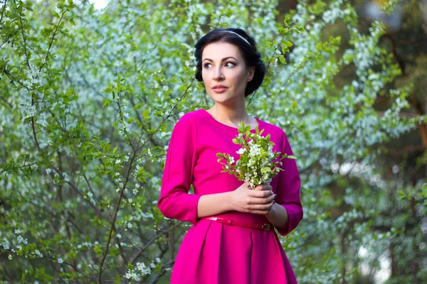 Mooie dromerige vrouw in cherry lentetuin — Stockfoto