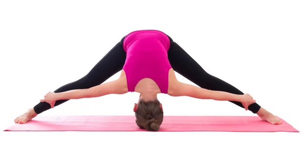 Slanke vrouw doen stretching oefening op yoga mat geïsoleerd op whi — Stockfoto