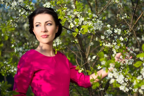 Portrait of young beautiful woman posing in blooming garden — Stock Photo, Image