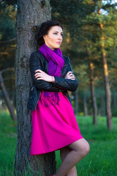 Beautiful woman standing near the tree in summer forest — Stockfoto