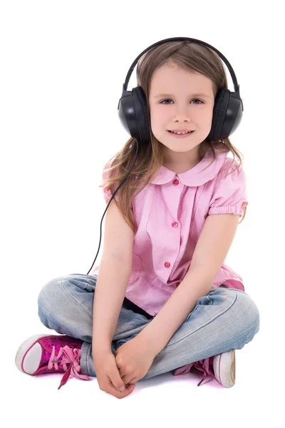 Cute little girl listening music in headphones isolated on white — Stock fotografie