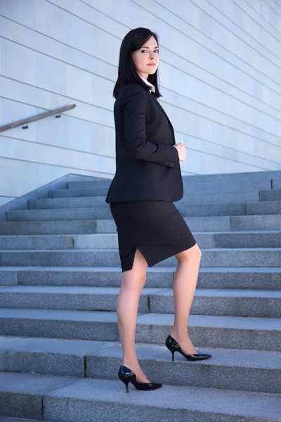 Career concept - beautiful business woman standing on stairs — Fotografia de Stock