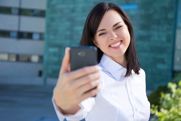 Funny business woman making selfie photo on smartphone — ストック写真