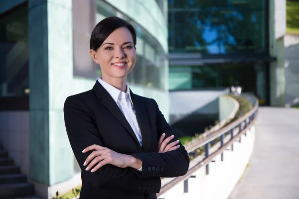 Business concept - beautiful woman in suit over modern city back — Stock Photo, Image