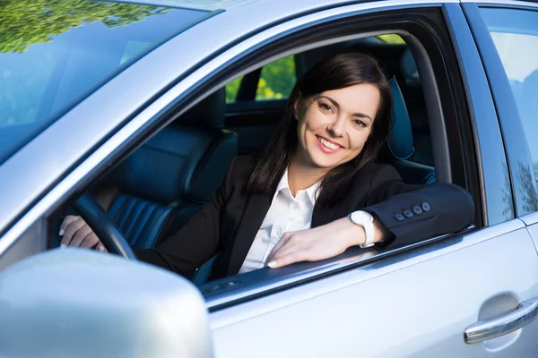 Young business woman sitting in her car — Stock Photo, Image
