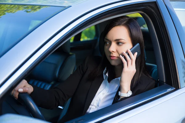 Успішна бізнес-леді розмовляє на смартфоні в її машині — стокове фото