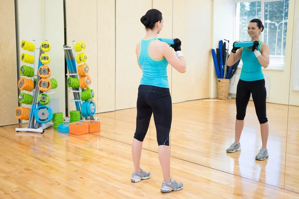 Mooie slanke vrouw uit te werken in de sportschool — Stockfoto