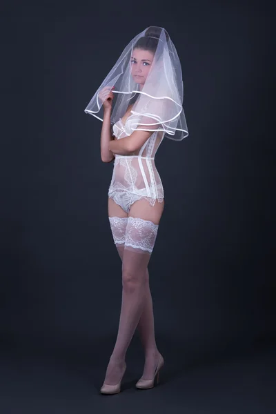 Mulher bonita em lingerie nupcial branco sobre cinza — Fotografia de Stock