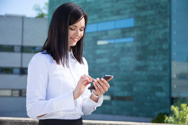 Zakenvrouw met smartphone in stad — Stockfoto