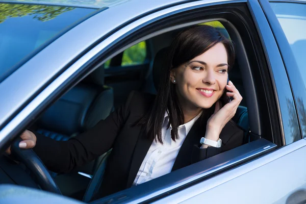 Щаслива успішна бізнес-леді розмовляє по телефону в її машині — стокове фото