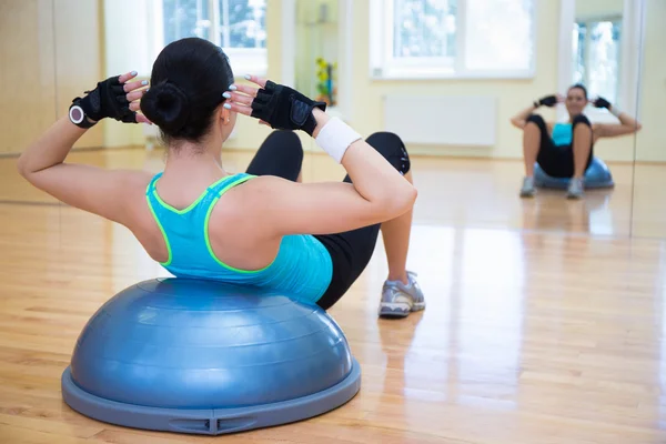 Ung kvinna gör övningar på bosu boll — Stockfoto