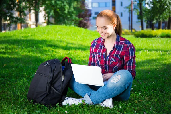 Genç öğrenci veya park içinde laptop ile oturan okul kız — Stok fotoğraf