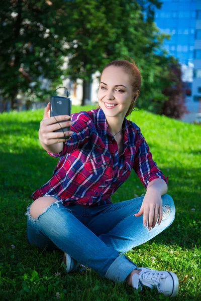 Дівчина-підліток слухає музику і робить селфі фотографію з розумним — стокове фото