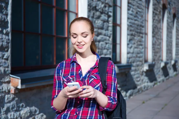 Mooi lachende tiener student meisje met telefoon en rugzak — Stockfoto
