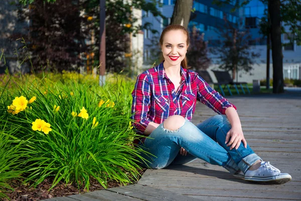 Ładna dziewczyna siedzi w lato park — Zdjęcie stockowe