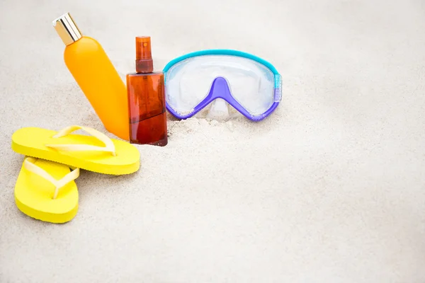 Fondo de playa - sandalias, botellas de la loción de bronceado y buceo — Foto de Stock