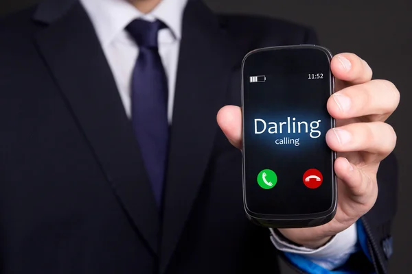 Male hand holding smart phone with incoming call from darling — Stock Photo, Image