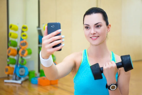 Красивый спортивный женщина, делая selfie фото с гантелями на smar — стоковое фото