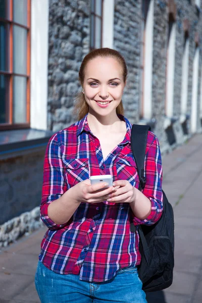 Güzel genç öğrenci kız ile telefon ve sırt çantası — Stok fotoğraf