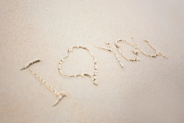 As palavras "Eu te amo" escrito na areia na praia — Fotografia de Stock