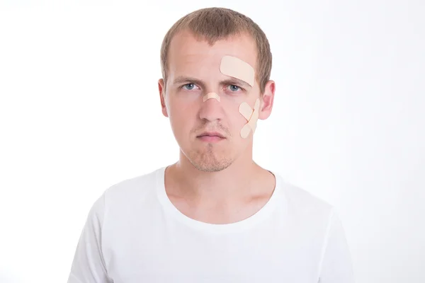 Portrait of sad and injured man with adhesive plaster on his fac — Stock Photo, Image