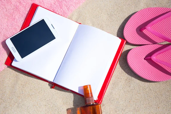 Concepto de verano - ojotas, toallas, teléfono, libro y bronceado lotio — Foto de Stock