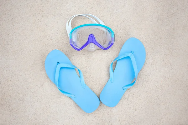 Conceito de praia - chinelos azuis e máscara de mergulho na areia — Fotografia de Stock