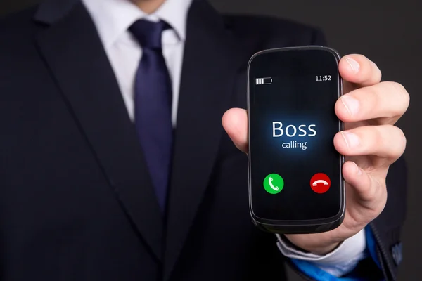 Mão do homem de negócios, segurando o telefone inteligente com chamada recebida do chefe — Fotografia de Stock