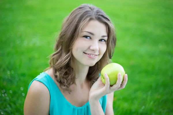 Retrato de mulher bonita feliz com a apple no parque — Fotografia de Stock