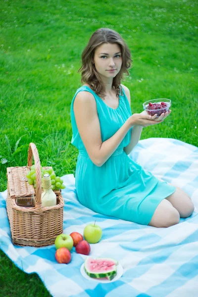 Bella donna sorridente con la frutta nel parco — Foto Stock