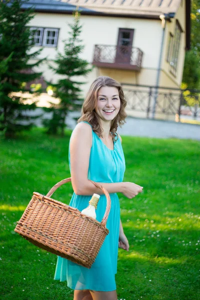 Femme heureuse avec panier pique-nique et bouteille de vin dans le parc — Photo