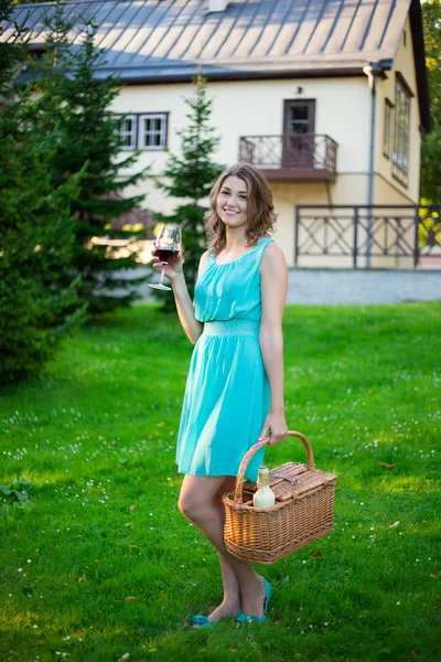 Mulher feliz com a cesta de piquenique, beber vinho no parque — Fotografia de Stock