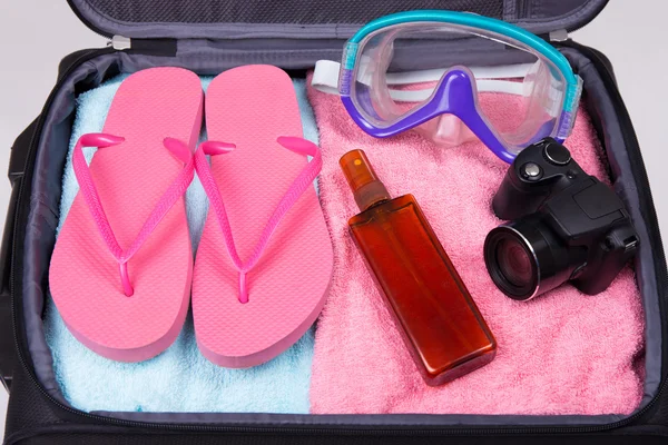 Nyaralás koncepció - csomagolt bőrönd, tele utazási cikkek — Stock Fotó