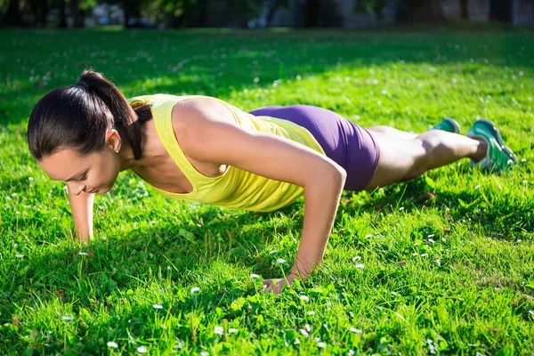 美丽的女人，做俯卧撑锻炼在公园 — 图库照片