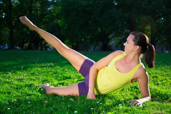 Женщина делает упражнения на растяжку в парке — стоковое фото