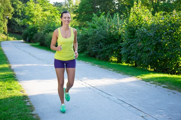 Happy slim jogging woman running in park — Stock Photo, Image