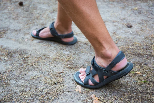 Mężczyzna nogi w sandałach chodzić na drodze — Zdjęcie stockowe