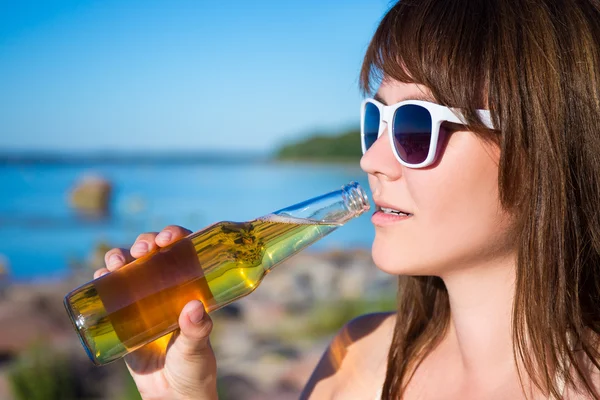 Linda mulher, beber cerveja na praia — Fotografia de Stock