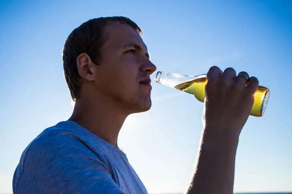 Close up portrait of young man drinking beer — Stok Foto