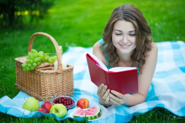 piknik sepeti ve kitap okuma meyve olan güzel kadın