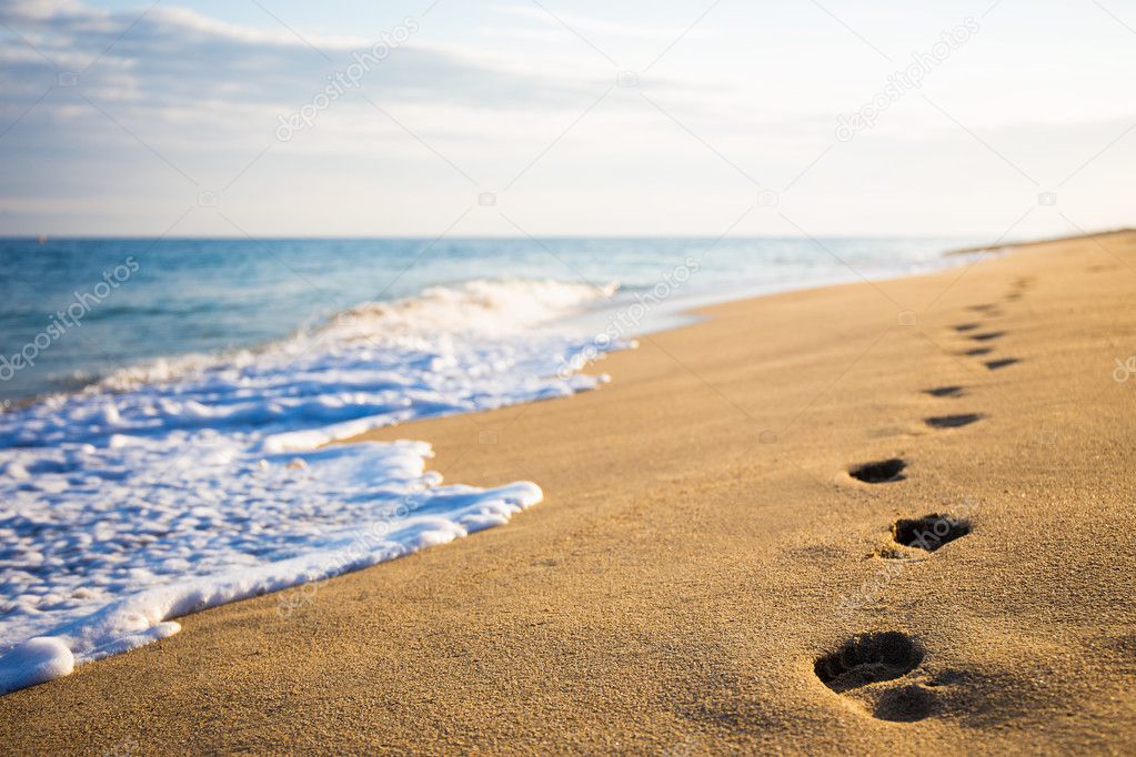 close up of footprints on sandy beach