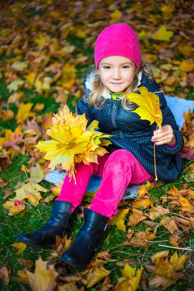 Glückliches kleine Mädchen mit Blumenstrauß aus Ahorn Blätter im Herbst-park — Stockfoto