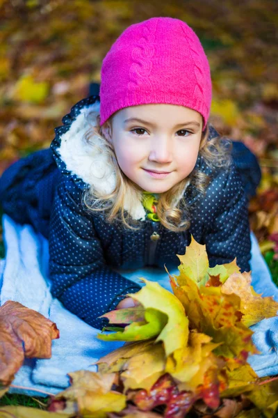 Schöne Mädchen mit Ahorn-Blätter im Herbst Park liegend — Stockfoto