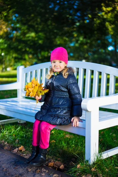 Porträt von schönen Mädchen auf der Bank mit Ahorn sitzen lassen — Stockfoto