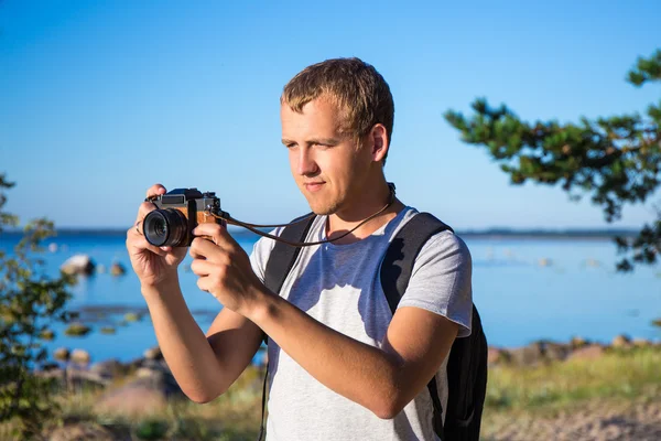 ビーチで写真を撮るバックパックを持つ男 — ストック写真