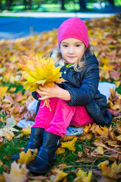 Kleines Mädchen mit Blumenstrauß aus Ahorn Blätter im Herbst-park — Stockfoto