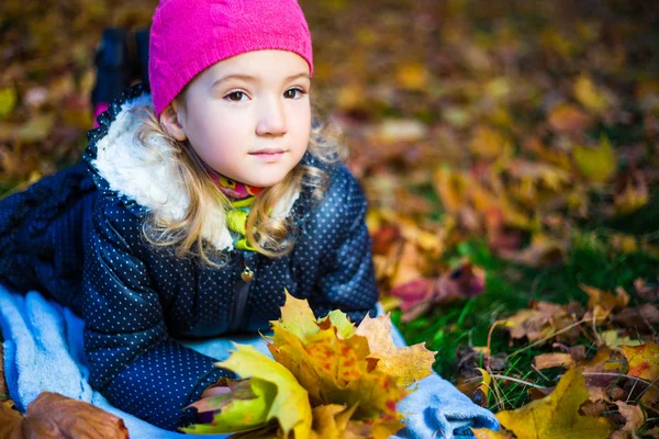 Emeryturze śliczną dziewczynkę z klon liści leżące w aut — Zdjęcie stockowe